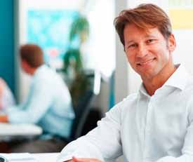 A smiling professional at his desk